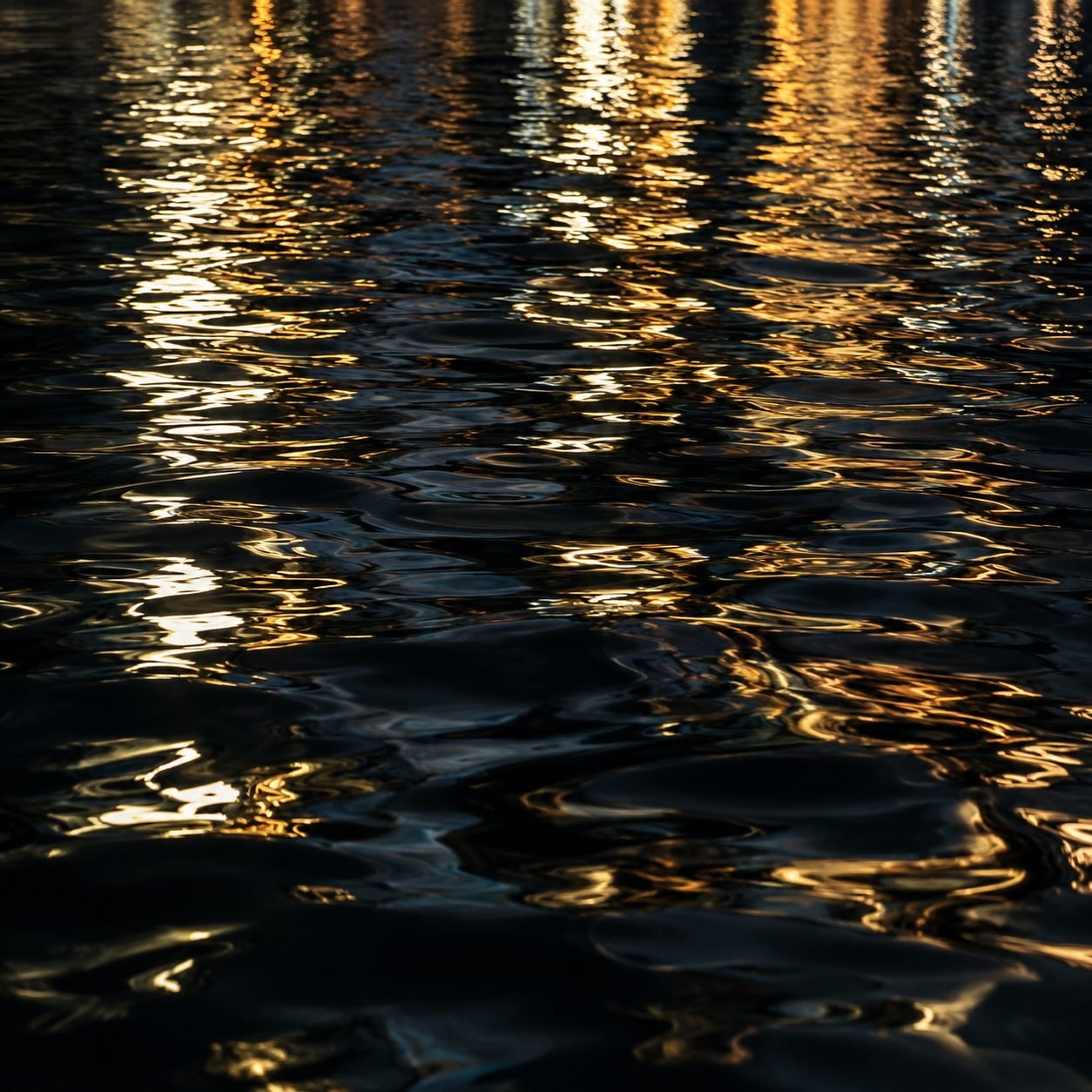 Close view of rippling water catching warm golden light.